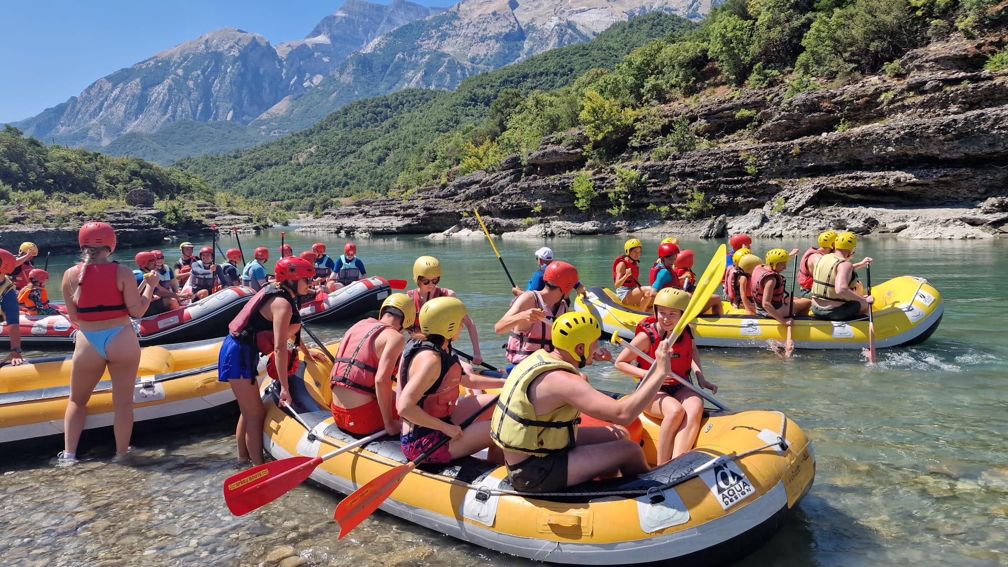 Group enjoying Vjosa River rafting experience in crystal-clear waters Albania